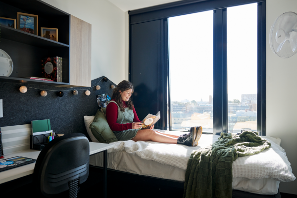 student sitting in student accommodation bedroom