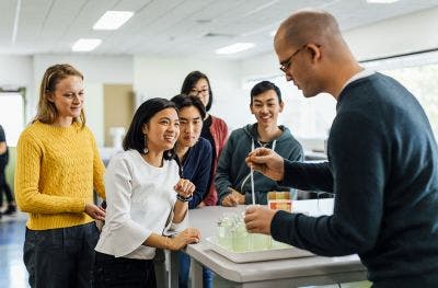 Students learning from teacher inside laboratory