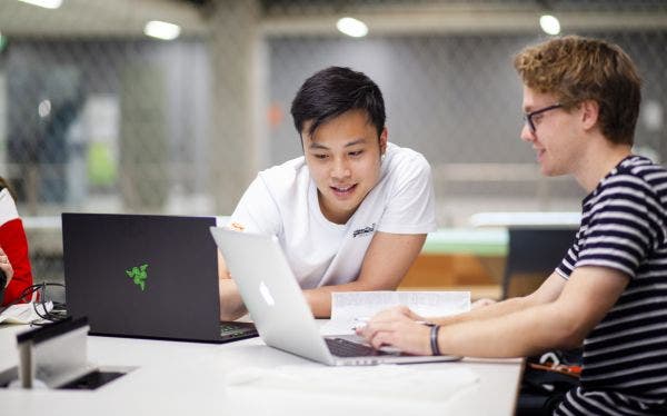 Two students working together over a laptop