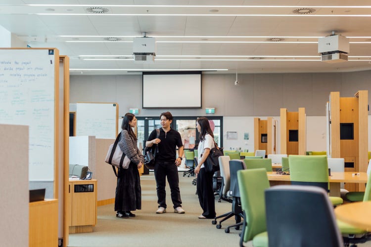 Three Agricultural Science students talking while standing in a communal study space.