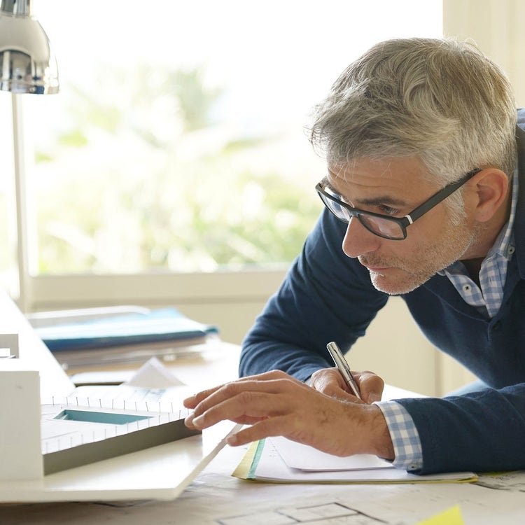 Architect in office working on 3D model.