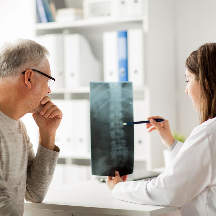 A health practitioner and patient discussing the patient's printed x-ray result.