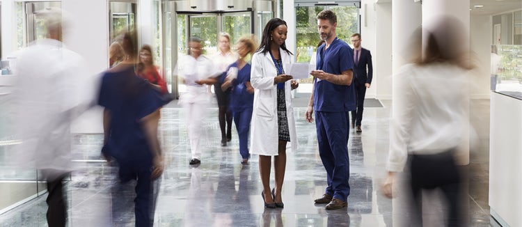 A hospital reception area filled with medical practitioners and visitors.