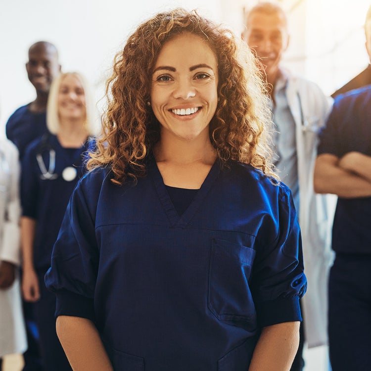 A diverse team of health practitioners in a hospital hallway.