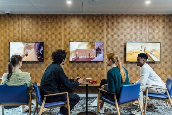 Four students watching TV in The Lofts common room