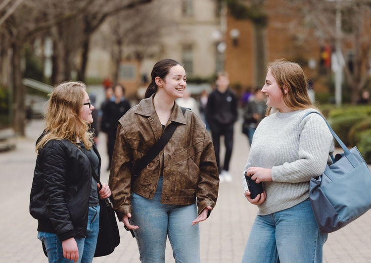 Three students talking on campus