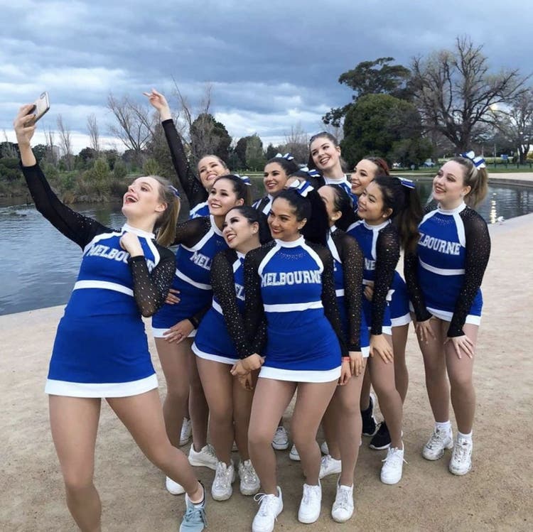 Cheerleading team taking a selfie by a pond