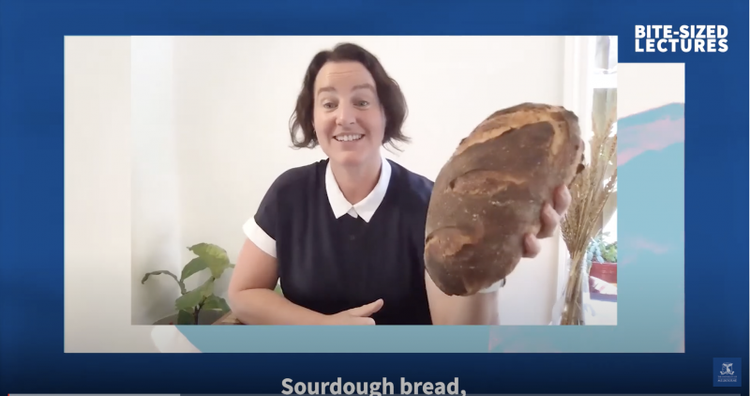 Dr Kate Howell, holding sourdough bread talking to camera