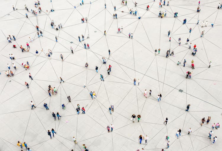 An aerial view of people scattered across a plaza, connected by thin black lines like a network diagram.