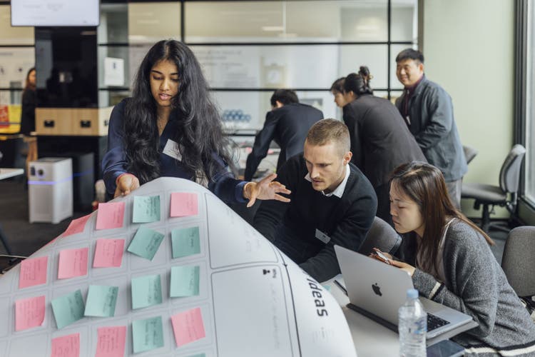 A group of students look over an ideas chart