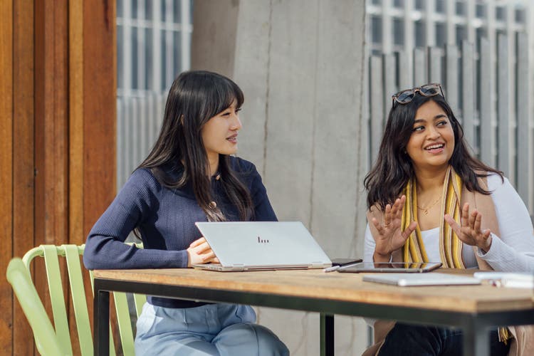 Post graduate students with laptops around a table