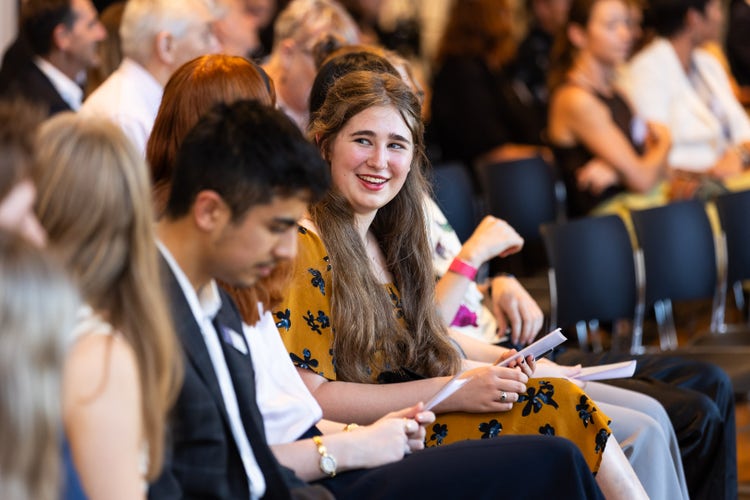 A Hansen Scholar sits amongst room full of students at award ceremony