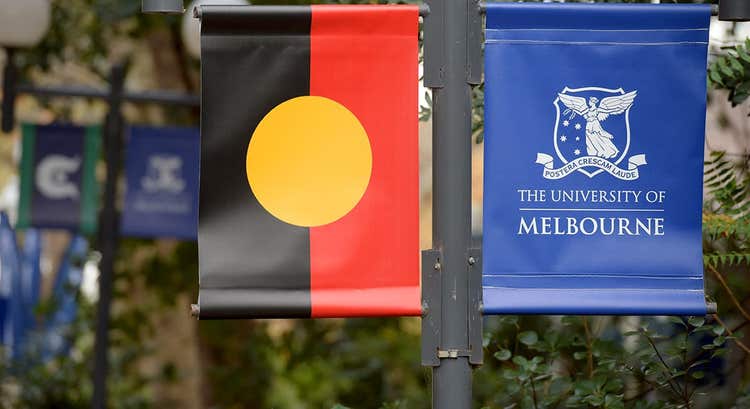 Aboriginal flag and University of Melbourne logo flag side by side