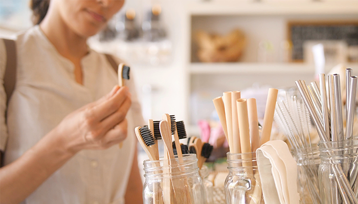 A woman inspects a bamboo toothbrush in a store