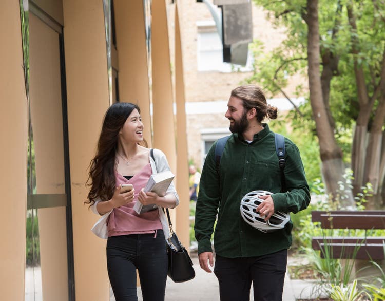 Two students walking through campus together